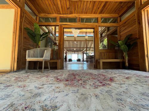 a large room with a wooden ceiling and a large rug at Aloha 5 in Ponta Mamoli