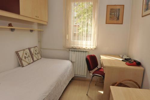 - une chambre avec un lit, un bureau et une chaise dans l'établissement Apartment Iva Tour As with balcony in Ljubljana, à Ljubljana