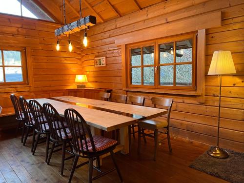 a dining room with a large wooden table and chairs at Schwarzwald Blockhaus Flößerhaus - Kaminofen, Sauna in Schenkenzell