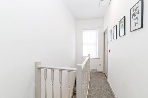 a white staircase in a room with white walls at Serviced Accommodation 5 Bedroom Holiday House in Liverpool