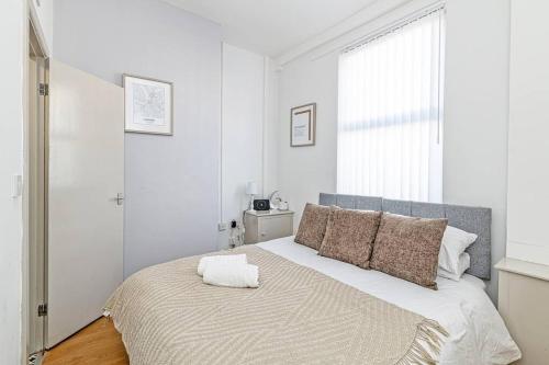 a white bedroom with a large bed with a window at Serviced Accommodation 5 Bedroom Holiday House in Liverpool