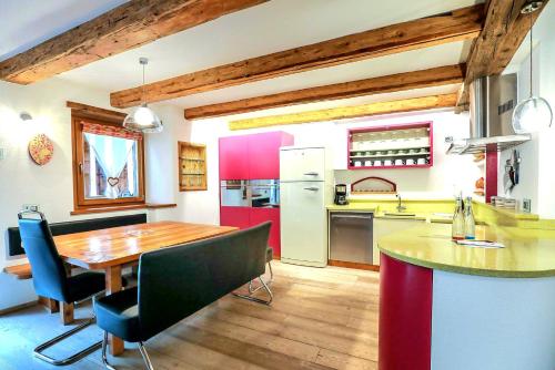 a kitchen with a wooden table and a dining room at Chalet Tobià in Canazei