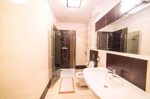 a bathroom with a sink and a toilet and a tub at Sanatorium Energetyk in Krynica Zdrój