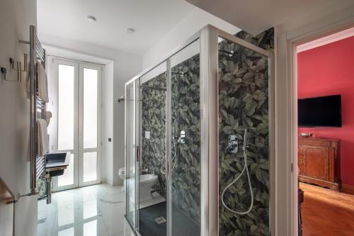 a bathroom with a walk in shower with a stone wall at Room 94 Luxury in Rome