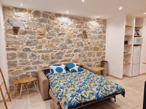 une chambre avec un lit et un mur en pierre dans l'établissement Superbe appartement en plein coeur d'Ajaccio, à Ajaccio