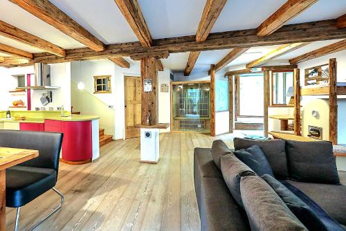 a living room with a couch and a kitchen at Chalet Tobià in Canazei