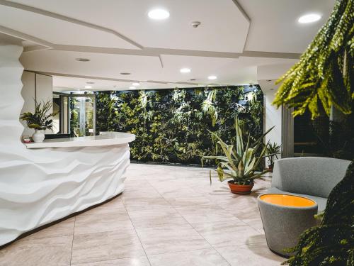 a lobby with a bar with plants in the background at Apartament Villa Łyna Park in Olsztyn