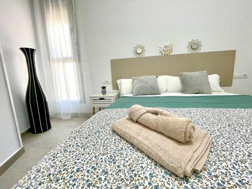 a bedroom with a bed with a blanket on it at GATU Villa Camarote con vistas al mar in Cádiz