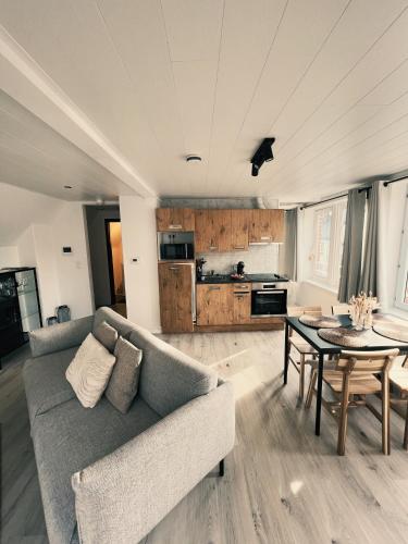 uma sala de estar com um sofá e uma mesa em Studio Sarah em De Panne