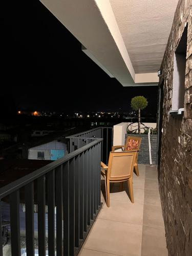 balcón con 2 sillas y vistas nocturnas en Apartament 2 camere Proximitate Aeroport, en Iaşi