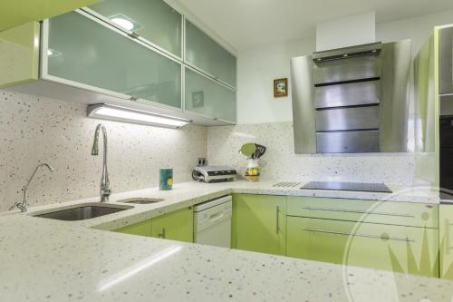 a kitchen with green cabinets and a sink at La Manga Club Resort - Bellaluz 4 in Atamaría