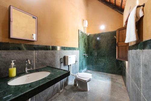 a bathroom with a sink and a toilet at CosmicStays Rustic Elegance - Traditional Wada Inspired Living in Shirwal