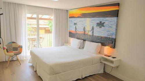 a bedroom with a bed and a painting on the wall at Parador Búzios Boutique Hotel in Búzios