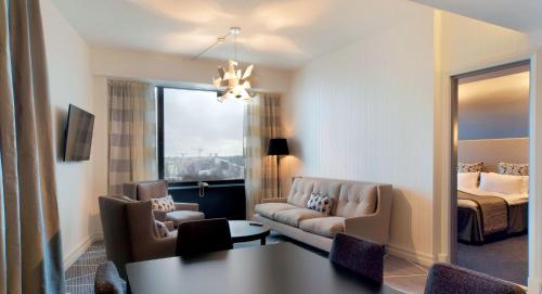 a living room with a couch and a bed at Crowne Plaza Helsinki - Hesperia by IHG in Helsinki