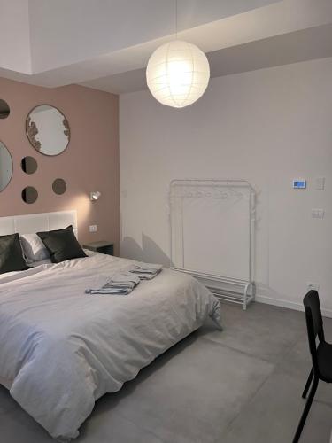 una camera bianca con un grande letto e una lampada di Quiet Room a Bologna