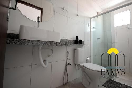 y baño con aseo, lavabo y espejo. en Baima's Residence, en Japaratinga
