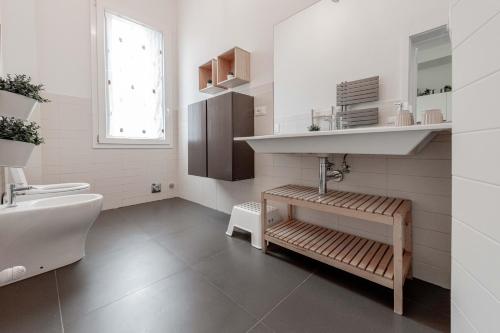 Baño blanco con lavabo y aseo en Realkasa De Crescenzi Family Apartment en Bolonia