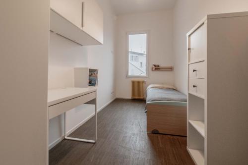 Habitación pequeña con escritorio y espejo. en Realkasa De Crescenzi Family Apartment en Bolonia
