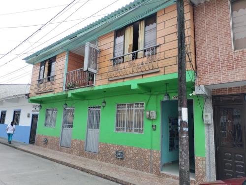 a green building on the side of a street at Casa Hotel Los Faroles- Samaná/Caldas in Samaná