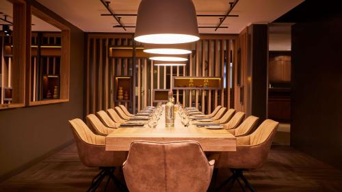 a long dining room with a long table and chairs at ATLANTIC Hotel Landgut Horn in Bremen