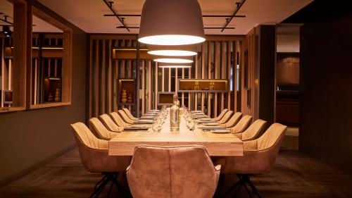 Długa jadalnia z długim stołem i krzesłami w obiekcie ATLANTIC Hotel Landgut Horn w Bremie