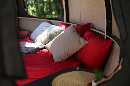 a group of pillows sitting on a red couch at Nature calls - tree tents in Būtingė
