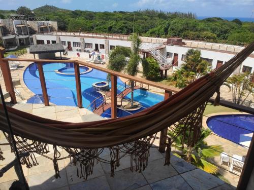 un balcón con hamaca y vistas a la piscina en Apto Vista Mar - Brisas do Amor 110, en Pipa