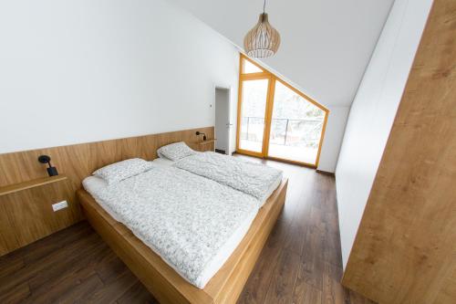 a bedroom with a bed and a large window at Apartman Cornus - Oravská Lesná in Oravská Lesná