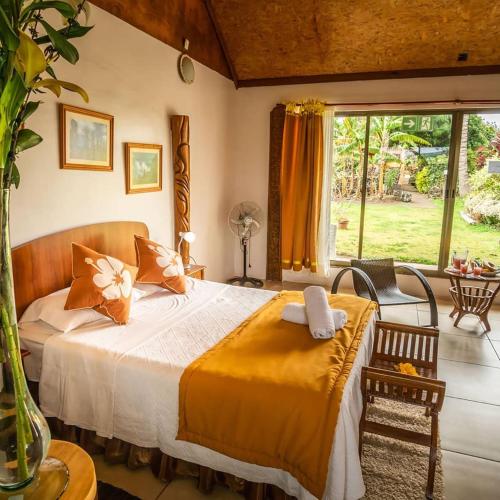 a bedroom with a bed and a large window at CHEZ MARIA GORETTI HOTEL in Hanga Roa