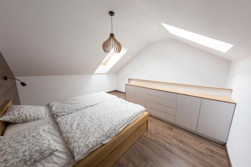 a white bedroom with a bed and a skylight at Apartman Cornus - Oravská Lesná in Oravská Lesná