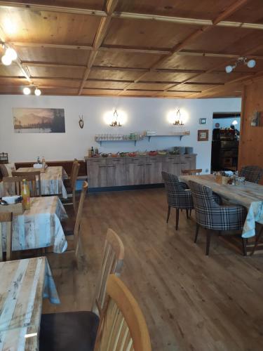 カンポ・トゥーレスにあるAppartments Waldblickのテーブルと椅子が備わるウッドフロアのレストランを併設しています。