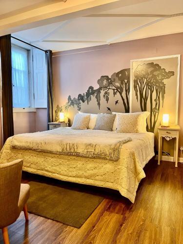 a bedroom with a bed with a painting on the wall at Chalet Saudade in Sintra