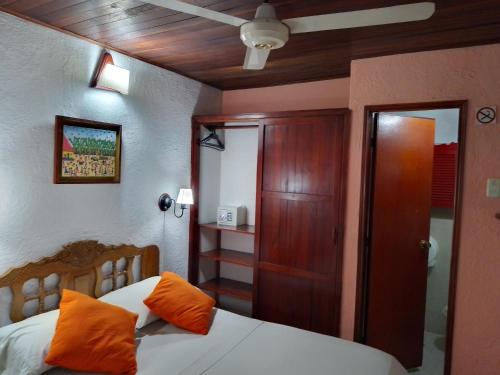 a bedroom with a bed with orange pillows on it at Hotel Nueva Granada in Santa Marta