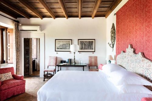 a bedroom with a white bed and a red wall at La Posta Vecchia Hotel in Ladispoli