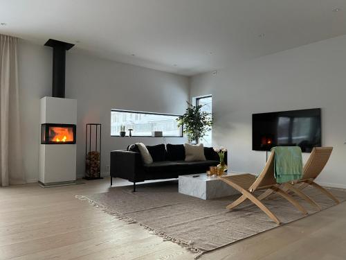 a living room with a black couch and a fireplace at North Apartment in Tromsø
