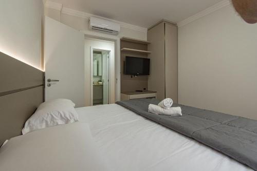 1 dormitorio con 1 cama con 2 toallas en Rosa Edifício Giardino Cattedral, en Canela