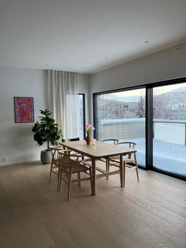 a dining room with a table and chairs and a large window at North Apartment in Tromsø