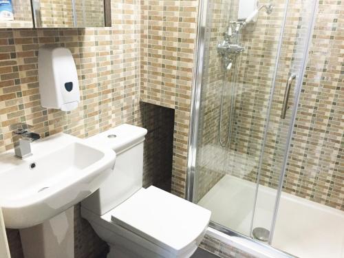 a bathroom with a toilet and a sink and a shower at Wellesley Road Apartments in Croydon