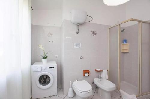 a bathroom with a washing machine and a toilet at Casa Salvo in Budoni