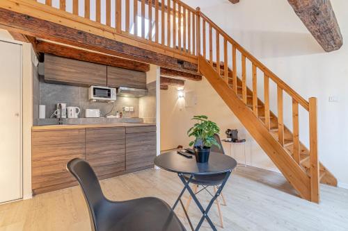 een keuken en eetkamer met een tafel en een trap bij Sous les Toits de Stanislas in Nancy