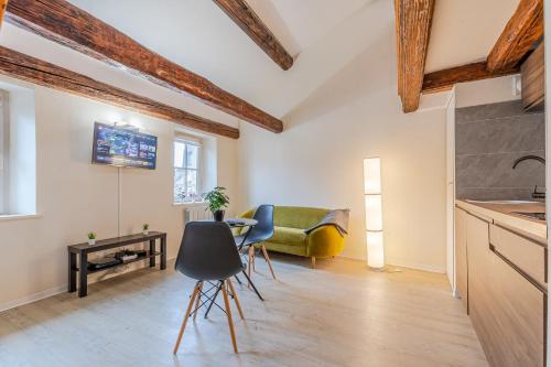 een keuken en een woonkamer met een tafel en stoelen bij Sous les Toits de Stanislas in Nancy