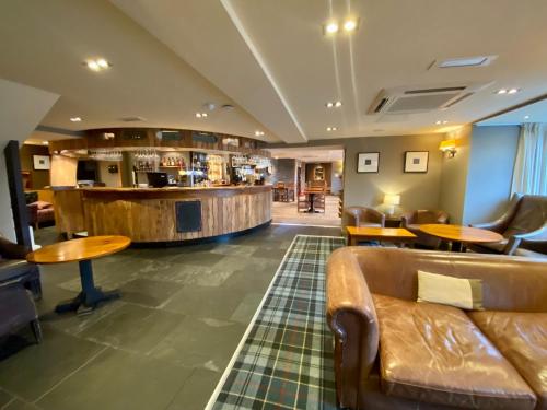 a lobby with a couch and a bar at The Inn on Loch Lomond in Luss