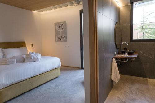 a bedroom with a bed and a bathroom with a window at BOX ART ALPINO in Navacerrada