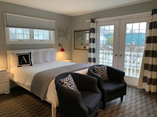 1 dormitorio con 1 cama grande y 2 sillas en Acadia Hotel - Downtown en Bar Harbor