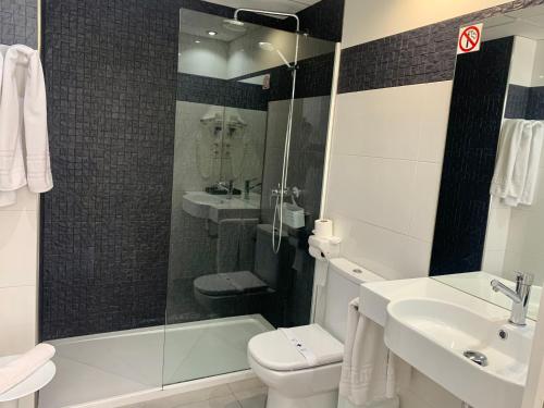 a bathroom with a toilet and a sink and a shower at Hospedium Hotel Continental in Mojácar