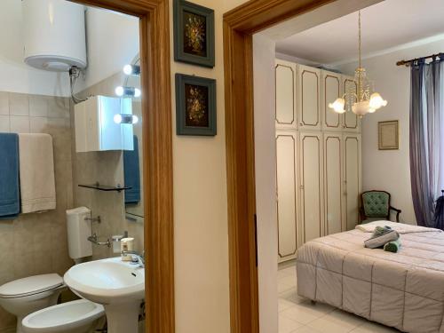 ein Bad mit einem Waschbecken, einem WC und einem Bett in der Unterkunft CasaTosca in Chianciano Terme