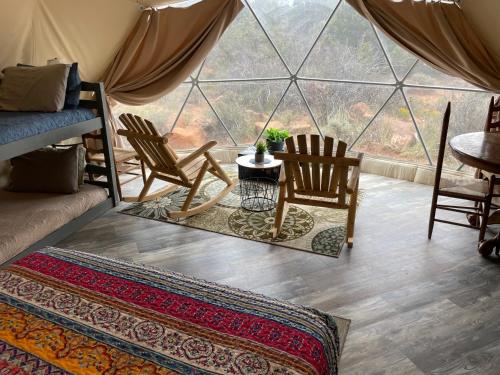 モンティセロにあるBlue Mountain Domes - The WOW Experienceのテント内の椅子とテーブル付きの部屋