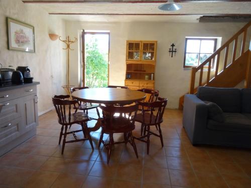 une cuisine et une salle à manger avec une table et des chaises dans l'établissement La Colline d'Eyzahut Gites en Drôme Provençale, à Pont-de-Barret