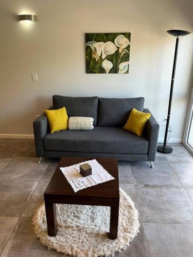 a living room with a couch and a coffee table at Frente a la playa, encantador departamento en PB in Puerto Madryn