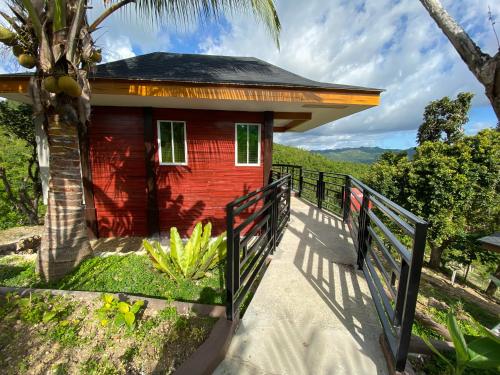 a small red house with a fence around it at MS Mountain Cabin in Loboc